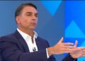 Flávio anota mensagens na mão durante sabatina na Globo